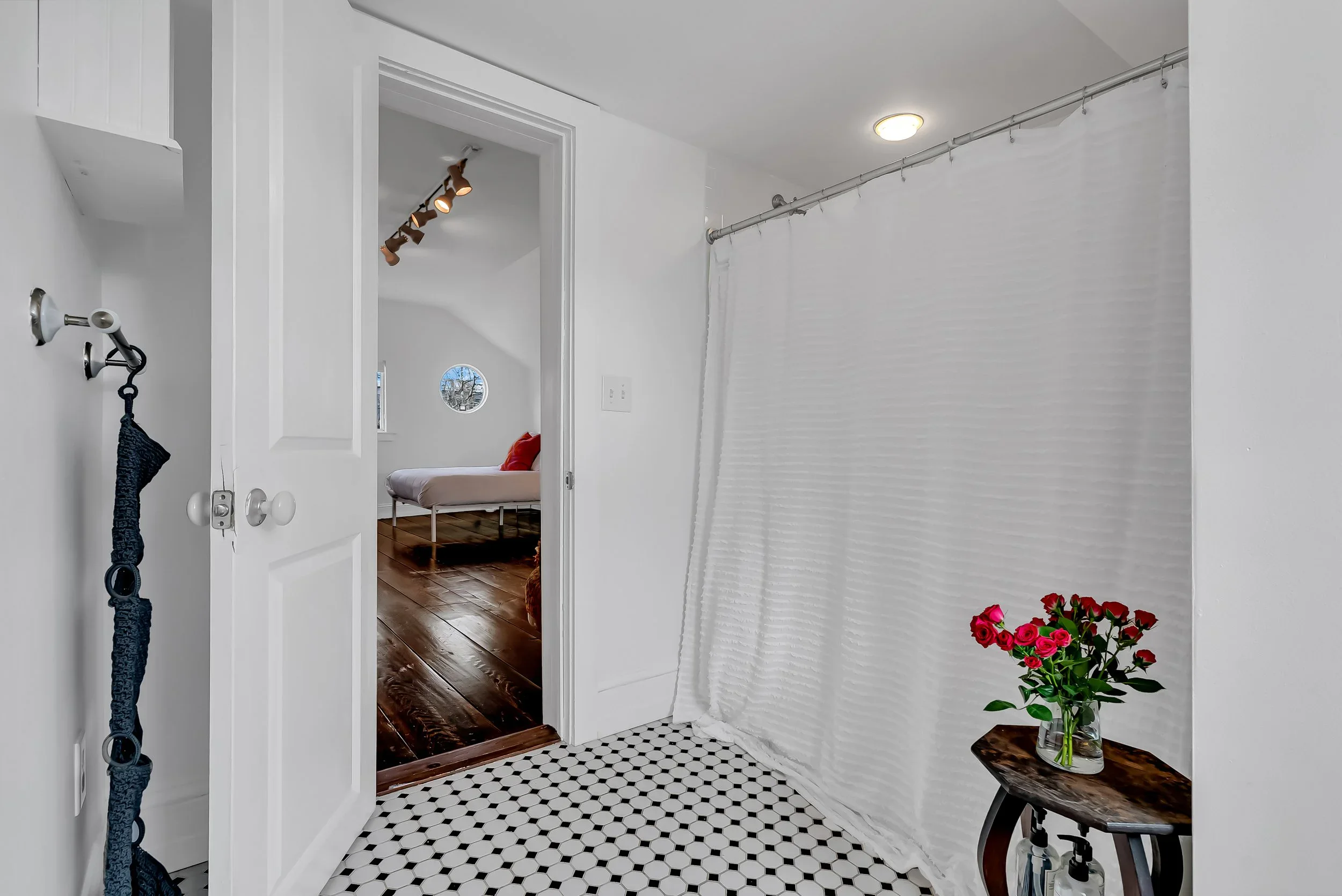 Full bathroom with a classic clawfoot-era tub, patterned tile, and soft natural light