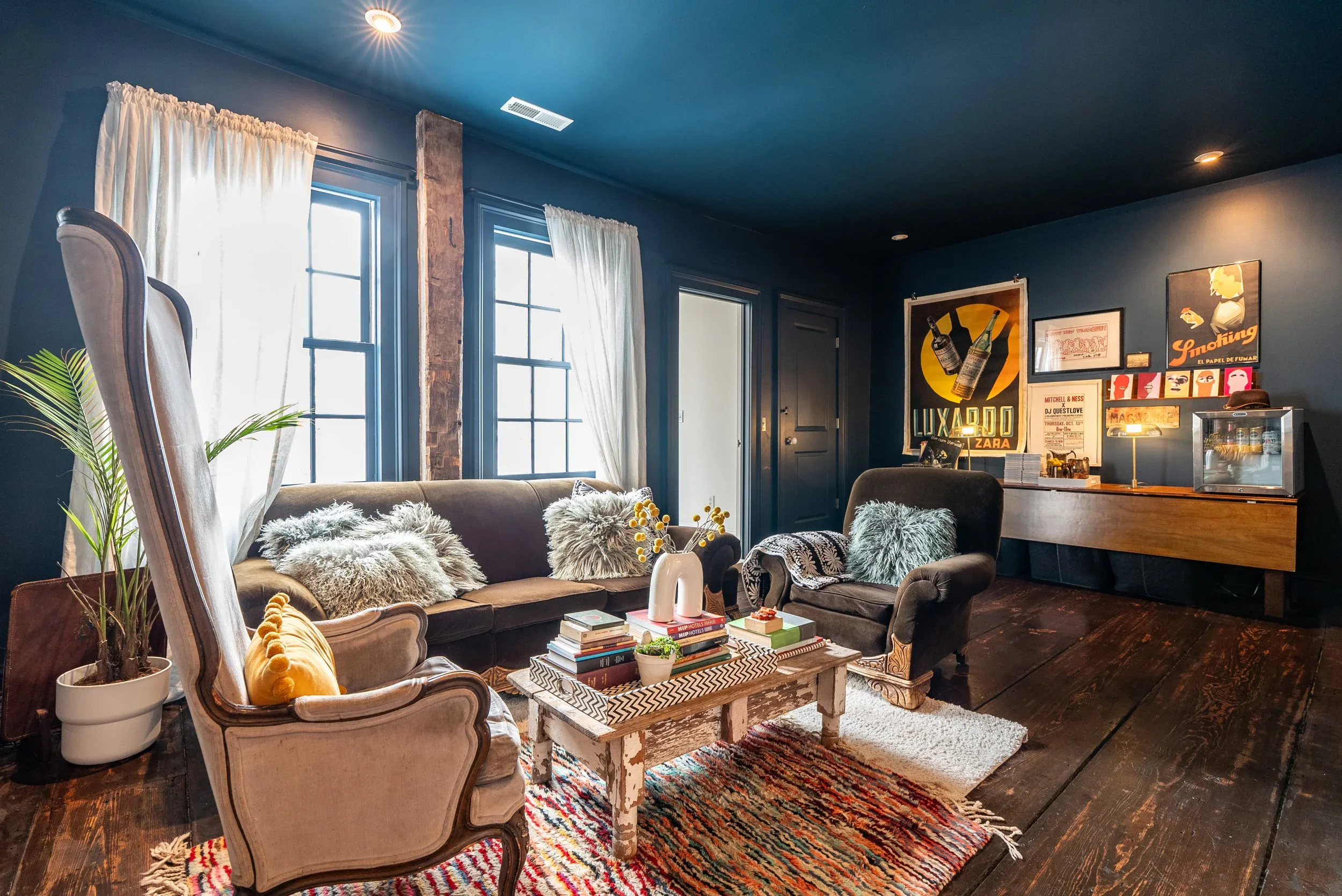 Relaxed lounge at Long Story Short with a deep sofa, throw blankets, and shelves of books and collected objects